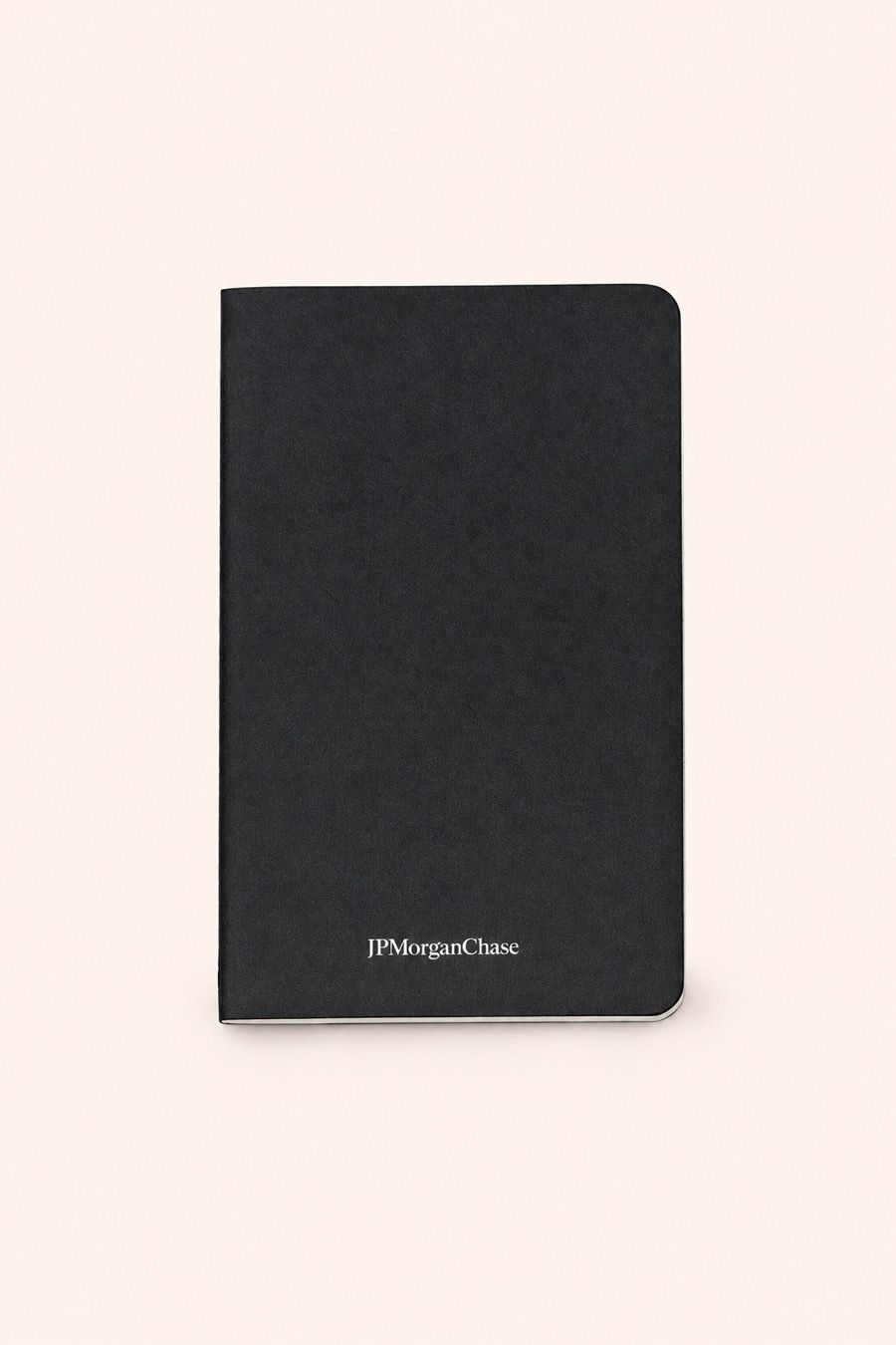 A black soft-cover journal with a small light wordmark near the lower edge of the cover.